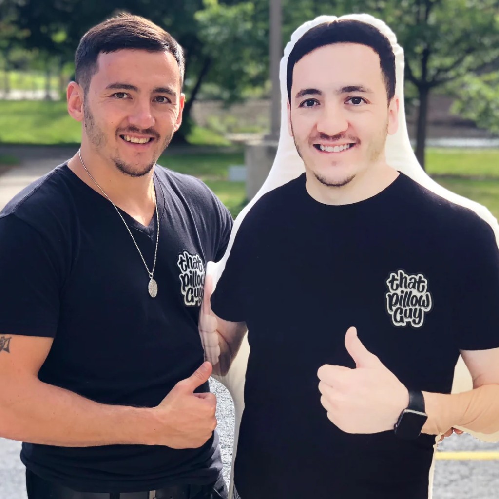 Man giving a thumbs up next to a life-size custom photo pillow of himself