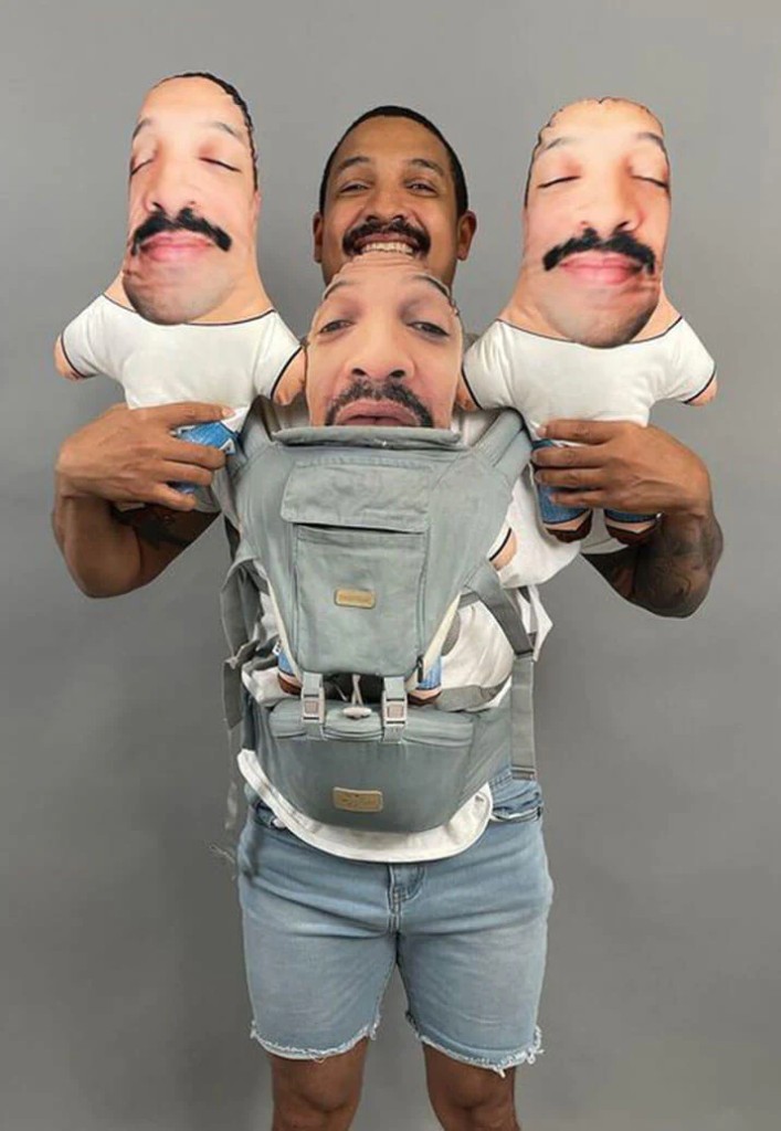 Man holding three custom mini-me face pillows